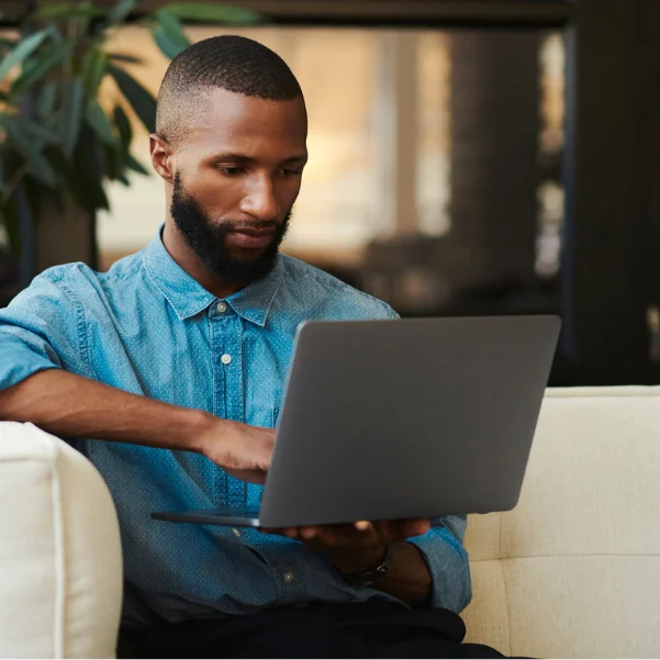 Wix: Ein Mann im blauen Hemd sitzt vor seinem Laptop