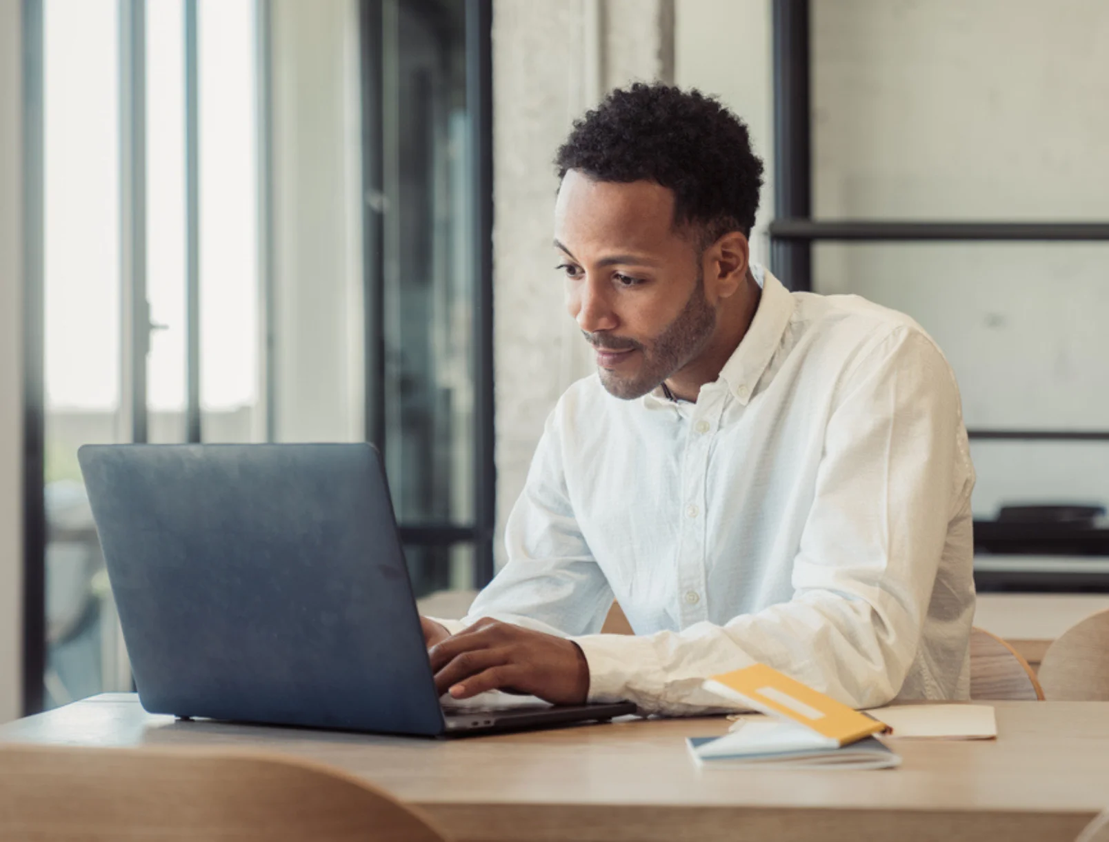 Ein Mann nutzt die kostenlose CRM-Software von Microsoft Dynamics 365 am Laptop, um Kundenkontakte und Vertriebsdaten effizient zu verwalten.