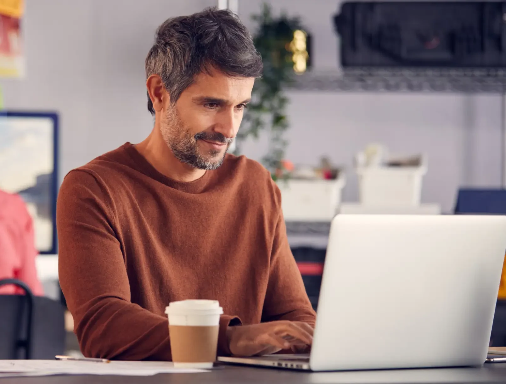 Ein Mann nutzt die kostenlose CRM-Software von Bitrix24 am Laptop, um Kundenkontakte und Vertriebsdaten effizient zu verwalten.